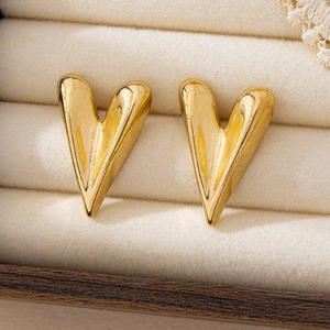 Elegant 3D heart-shaped gold studs in a minimalist geometric style on velvet display