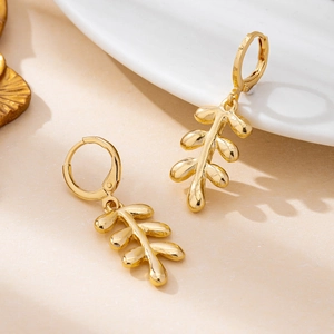 Elegant gold leaf branch drop earrings with polished finish and secure hoop closure