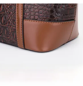 Detail shot of brown crocodile pattern leather and smooth stitching on a shell bag