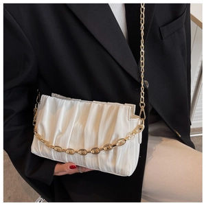 Close-up of white ruched cloud bag with premium gold chunky metal chain strap
