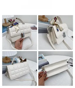 Close-up of white quilted crossbody bag with floral scarf handle and silver metal clasp