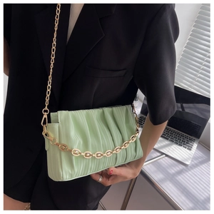 Close-up of light green pleated shoulder bag with gold chain and pearl strap detail