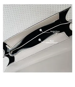 Detail of the inner compartments and silver zipper closure on the beige shoulder bag