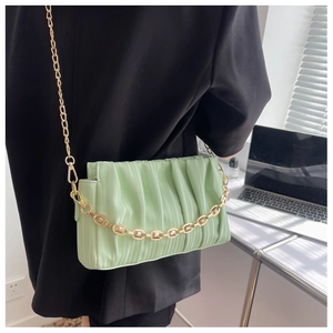 Detailed view of light green pleated shoulder bag with gold chain and leather strap