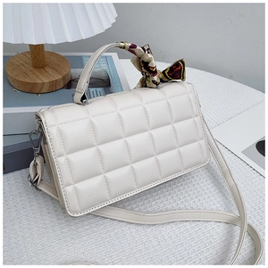 Quilted beige leather handbag detail with vintage geometric silk scarf on handle