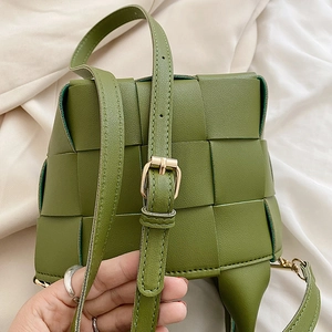 Detail of avocado green woven leather bag with gold buckle and adjustable strap