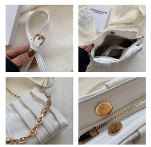 Detail showing white pleated texture bag with gold chain strap and magnetic closure