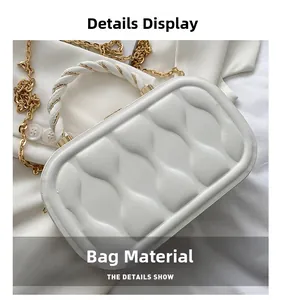 Detail of white box bag featuring embossed geometric texture and gold chain strap