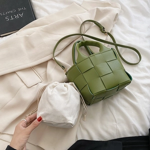 Detailed shot of green woven leather bucket bag with inner pouch and adjustable strap