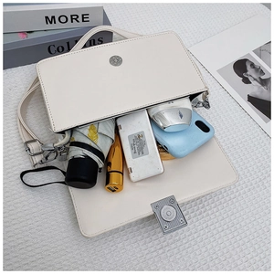 Internal capacity of white rectangle handbag showing phone, power bank and mini umbrella