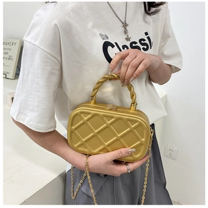 Detail of gold hard-shell crossbody bag with quilted pattern and metal chain strap