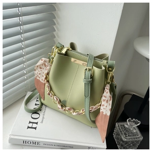 Modern light green bucket bag with leopard scarf chain handle on home decor book