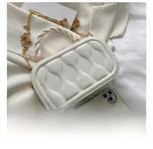 Size comparison of white quilted box bag with chain strap next to a mobile phone
