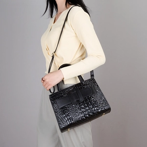 Women's black crocodile embossed handbag with crossbody strap and top handles