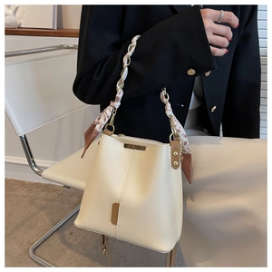 Creamy white chain bucket bag with silk scarf handle and brown leather contrast detail