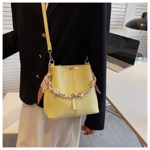 Fashionable yellow PU leather bucket bag with chain strap and floral silk scarf detail