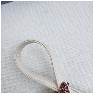 Detailed close-up of warm white leather strap showing precise stitching and edge finishing