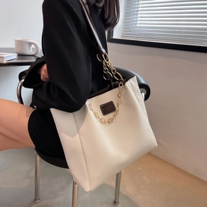 White PU leather tote bag with black trim and gold chain floral detail for women