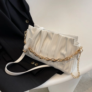 White ruched cloud bag with gold chain and crossbody strap on minimalist background