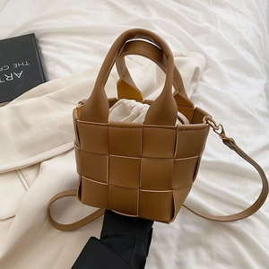 Detail of woven caramel bucket bag with drawstring liner and detachable shoulder strap
