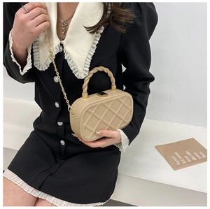 Detail of beige quilted mini crossbody bag with a braided handle and metal chain strap