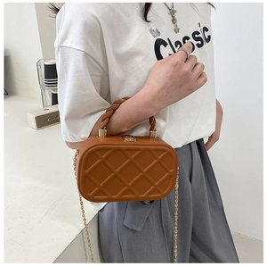 Brown quilted crossbody bag with gold chain strap shown on model for size perspective