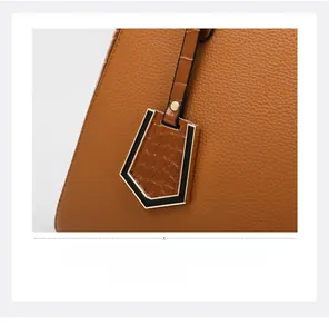 Close-up of caramel brown tote with litchi and crocodile leather texture detail