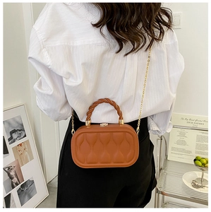 Brown capsule crossbody bag featuring unique wavy quilted texture and gold chain strap