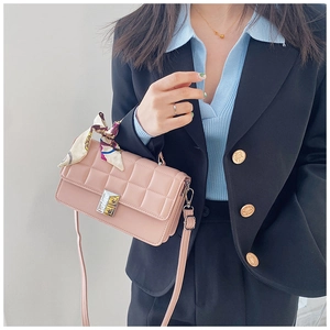 Detailed view of a pink quilted crossbody bag with gold buckle and floral scarf handle