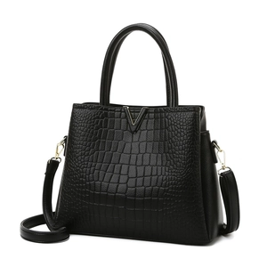 Elegant black crocodile-patterned handbag with golden V hardware and dual handles