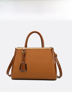 Close-up of brown faux leather tote bag with crocodile texture and golden metal bar