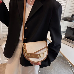 Chic two-tone crocodile pattern saddle bag with gold chain and ring hardware on a model