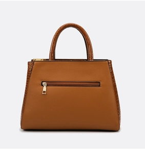 Detail of brown faux crocodile and litchi grain leather stitching on women's tote bag