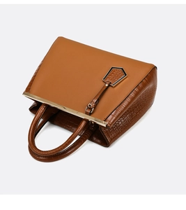 Close-up of caramel tote bag featuring crocodile pattern texture and gold metal hardware