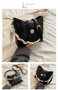 Detail of black quilted bucket bag featuring decorative silk scarf chain handle and round buckle