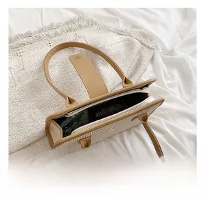 Detail showing the inner capacity of this cream pleated handbag with a brown handle