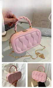 Detailed view of pink mini box bag with wavy quilting and gold metallic handle