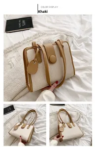 Detail of khaki pleated handbag with round snap closure and textured vertical folds