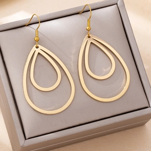 Gros plan de boucles d'oreilles goutte dorées sur une boîte à bijoux, lumière douce