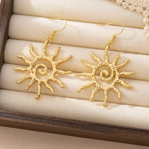 Boucles d'oreilles soleil dorées élégantes de style bohème dans une boîte à bijoux vintage