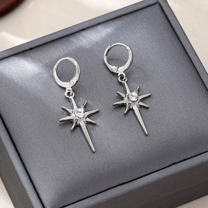 Elegant silver starburst drop earrings with sparkling zircon on dark jewelry box