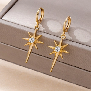 Detailed view of gold starburst hoop earrings with a center crystal on a leather box