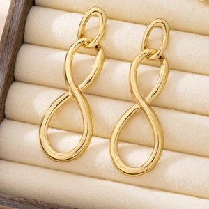 Vue détaillée de boucles d'oreilles nœud doré sur un présentoir en velours beige