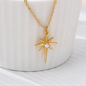 Macro view of gold North Star pendant necklace with sparkling center zircon detail