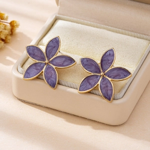 Elegant purple enamel flower earrings with gold plating on a beige velvet jewelry box