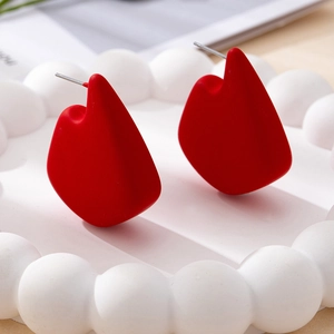 Exquisite geometric red stud earrings with matte finish on a decorative white tray