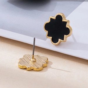 Minimalist black floral stud earrings with golden wavy edges and textured back surface