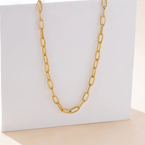 Macro shot of gold paperclip chain link texture with polished oval finish for daily wear