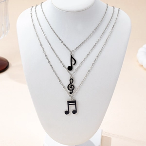 Ensemble de trois colliers superposés avec pendentifs notes de musique en émail noir