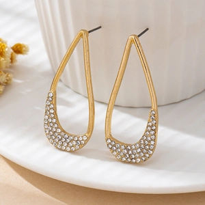 Detail of pear-shaped drop earrings with micro-set rhinestones on a gold hollow frame